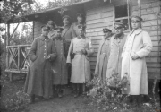 Soldaten während des Ersten Weltkriegs vor einem einfachen Holzgebäude in einer ländlichen Umgebung