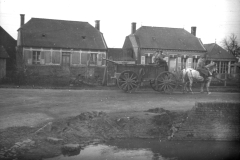 Soldaten transportieren Waren mit einer Pferdekutsche in einem belagerten Dorf während des Ersten Weltkriegs