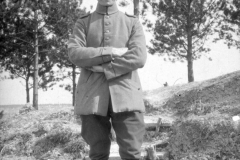 Soldat im Ersten Weltkrieg steht an einer Treppe in einem Waldgebiet
