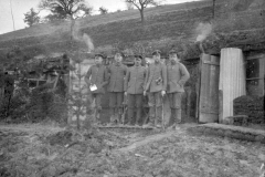 Soldaten des Ersten Weltkriegs stehen vor einem Unterstand in der Natur während einer ruhigen Phase des Konflikts
