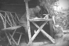 Soldat sitzt an einem Tisch und schreibt während des Ersten Weltkriegs in einem Graben