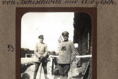 Zwei Soldaten im Ersten Weltkrieg vor einem Holzgebäude in einer militärischen Umgebung