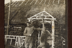 Soldat während des Ersten Weltkriegs mit erlegtem Tier vor einem Bauernhaus