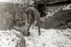 Im Winter Holz hacken: Ein Handwerker bei der Arbeit in einer verschneiten Landschaft