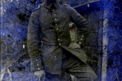 Soldat in historischer Uniform posiert in einer bewaldeten Umgebung während des Ersten Weltkriegs