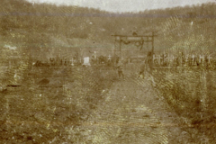Ein historischer Moment: Ein Festzug über einen ausgetrockneten Weg zwischen Ehrengräbern in der Natur