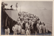 Auf dem Deck eines Schiffes versammeln sich zahlreiche Seeleute während einer ruhigen Seefahrt