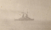 Schiffsnebel über dem Meer mit Silhouette eines Kriegsschiffes während des Morgengrauens