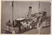 Soldaten und Matrosen auf einem historischen Dampfschiff an einem ruhigen Gewässer in der Vergangenheit