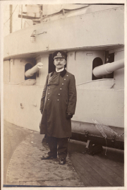 Ein Offizier der Heer steht stolz an Bord eines historischen Kriegsschiffs in den frühen 1900er Jahren