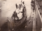 Arbeiter des Heeres auf einem Schlepper bei der Hafenmanipulation