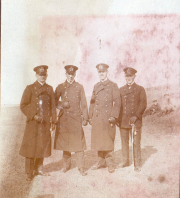Historisches Porträt von vier Offizieren in Uniform vor einer Kaserne in der Heer