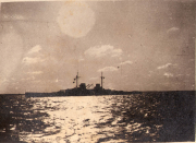 Kriegsschiff auf dem Wasser während des Hafenanlaufes bei Sonnenuntergang