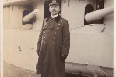 Ein Offizier der Heer steht stolz an Bord eines historischen Kriegsschiffs in den frühen 1900er Jahren
