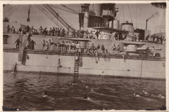 Paddelnde Männer vor einem Schiff während einer Sommertagesaktivität in der historischen Heer