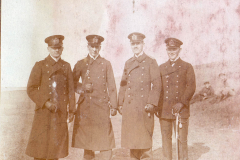 Historisches Porträt von vier Offizieren in Uniform vor einer Kaserne in der Heer