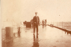 Mann auf dem Deck eines Schiffes während einer nassen und nebligen Tagesfahrt auf dem Meer
