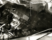 Die Aufnahme zeigt das völlig verwüstete Innere eines Kriegsschiffes mit verbogenen Metallteilen, Trümmern und zerstörten Aufbauten. Die schweren Schäden deuten auf Kampfeinwirkung oder Explosion hin.