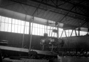 Ein Doppeldecker-Flugzeug steht in einer großen Werkhalle mit Glasdach und Stahlkonstruktion. Die Aufnahme zeigt die industrielle Flugzeugproduktion der Kaiserlichen Marine während des Ersten Weltkriegs.