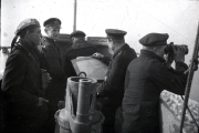Mehrere Offiziere der Kaiserlichen Marine versammeln sich um einen Sextanten auf der Brücke eines Schiffs. Die Aufnahme zeigt eine typische Navigationsszene während einer Fahrt im Ersten Weltkrieg.