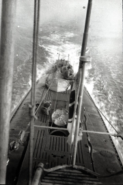Die Aufnahme zeigt das Vorderdeck eines deutschen U-Bootes der Kaiserlichen Marine während der Fahrt auf See. Mehrere Besatzungsmitglieder sind auf dem Deck zu erkennen, während das Boot durch bewegte See fährt.