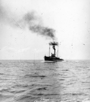 Ein Dampfschiff mit zwei Schornsteinen stößt dichte schwarze Rauchwolken aus, während es auf offener See fährt. Die Aufnahme stammt aus dem Kontext der U-Boot-Kriegsführung im Ersten Weltkrieg.