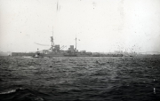 Ein großes Schlachtschiff der deutschen Kaiserlichen Marine fährt bei mäßigem Seegang. Das Kriegsschiff zeigt die charakteristische Silhouette mit mehreren Geschütztürmen, Aufbauten und Schornsteinen.