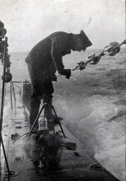 Ein Marineoffizier führt bei schwerem Seegang eine Positionsbestimmung mit dem Sextanten auf der Brücke eines U-Bootes durch. Das Bild zeigt die schwierigen Bedingungen der Navigation bei hohem Wellengang während einer Feindfahrt.