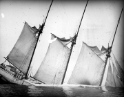 Ein großes Segelschiff mit vier Masten sinkt im Meer, wobei die Segel noch gesetzt sind und das Schiff bereits eine starke Schlagseite aufweist. Die Aufnahme dokumentiert eine Schiffsversenkung während des U-Boot-Krieges im Ersten Weltkrieg.