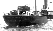 Ein deutsches Torpedoboot zeigt massive Zerstörungen am Heckbereich mit völlig demoliertem Geschützturm und aufgerissenen Strukturen. Das beschädigte Kriegsschiff liegt vermutlich in einem Hafen vor Anker.