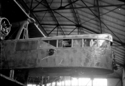 Ein Flugzeug befindet sich in einer großen Werkhalle mit charakteristischer Stahlkonstruktion und Glasdach. Die Aufnahme zeigt das Flugzeug während der Montage oder Wartungsarbeiten in der Flugzeugproduktion.