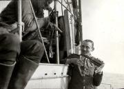 Zwei Marinesoldaten der Kaiserlichen Marine musizieren auf dem Deck eines Kriegsschiffs, einer spielt Geige. Die Aufnahme zeigt eine entspannte Szene während einer Fahrt im Ersten Weltkrieg.