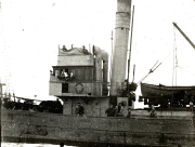 Ein deutsches Torpedoboot der Kaiserlichen Marine mit mehreren Besatzungsmitgliedern auf Deck und Brücke. Das Kriegsschiff zeigt typische Aufbauten mit Schornstein, Brückenhaus und Rettungsboot an Deck.