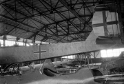 Mehrere Flugzeuge befinden sich in einer großen Industriehalle mit Stahlkonstruktion und Glasdach. Die Maschinen tragen deutsche Hoheitszeichen und scheinen sich in verschiedenen Produktions- oder Wartungsstadien zu befinden.