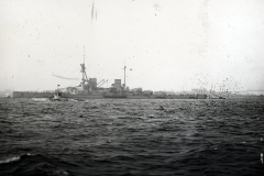Ein großes Schlachtschiff der deutschen Kaiserlichen Marine fährt bei mäßigem Seegang. Das Kriegsschiff zeigt die charakteristische Silhouette mit mehreren Geschütztürmen, Aufbauten und Schornsteinen.