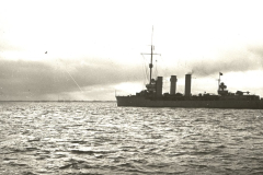 Ein Kreuzer mit drei charakteristischen Schornsteinen und Masten fährt bei ruhiger See. Die Aufnahme entstand im Kontext der U-Boot-Operationen von S.M. U 39 unter Walter Forstmann.