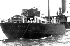 Ein deutsches Torpedoboot zeigt massive Zerstörungen am Heckbereich mit völlig demoliertem Geschützturm und aufgerissenen Strukturen. Das beschädigte Kriegsschiff liegt vermutlich in einem Hafen vor Anker.