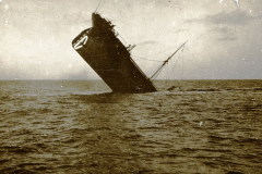 Ein Dampfschiff sinkt mit dem Bug voran ins Meer, während die Masten noch aus dem Wasser ragen. Die Aufnahme dokumentiert eine Schiffsversenkung während des U-Boot-Krieges im Ersten Weltkrieg.