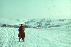 Frau in Winterlandschaft mit Blick auf russische Siedlung