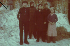 Gruppe von fünf Personen in Winterkleidung in verschneiter Landschaft