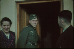 Deutscher Luftwaffenoffizier in Innenraum mit Zivilpersonen