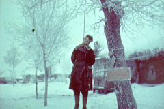 Person in rotem Mantel unter schneebedeckten Bäumen in Russland