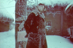 Frau in Winterkleidung an verschneitem Baum in Russland
