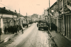 Straßenszene in einer Balkanstadt mit Militärfahrzeug während der Besatzung