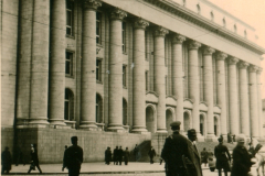 Neoklassizistisches Gebäude mit Kolonnadenfassade und Zivilpersonen auf Platz