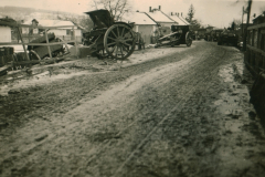 Dorfstraße mit Pferdefuhrwerken und Militärfahrzeugen auf dem Balkan