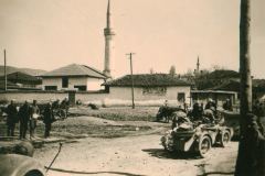 Militärische Aktivität in Balkanort mit Moschee und Fahrzeugen