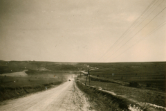 Feldstraße mit Stromleitung in hügeligem Gelände, Balkan 1941-1943