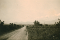 Landstra?e in Balkanregion mit Bergpanorama und Siedlung