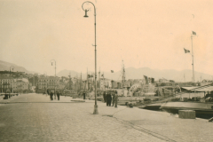 Hafenplatz einer Balkanstadt mit Flaggendekorationen während der deutschen Besatzung